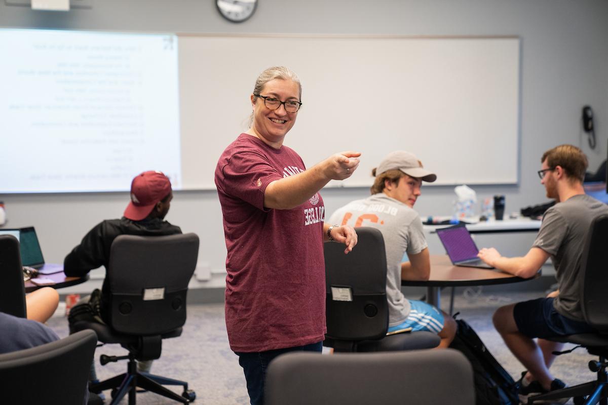 Professor points at students and smiles